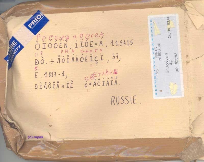 A package going between Russia and Paris, written in Mojibake because of interpreting text with the wrong encoding. It has been corrected in marker with the correct lettering, because they are so used to this occurence for international packages.
